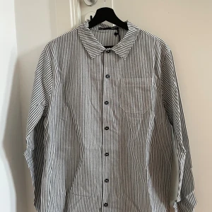 Randig skjorta från Lager 157 - Svart/vitrandig skjorta från Lager 157 i storlek S. Ej använd, prislapp sitter kvar på plagget