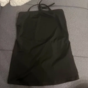 Svart axelbandslös fest topp med knytning i ryggen - Snygg svart axelbandslös topp med knytband i ryggen