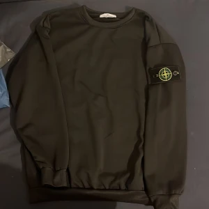 Svart sweatshirt från Stone Island - Snygg svart sweatshirt från Stone Island med det ikoniska märket på ärmen. Inte använd helt ny