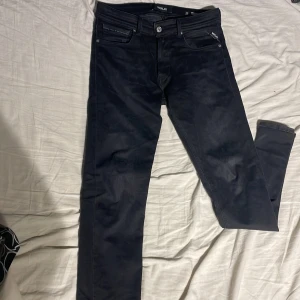 Svarta jeans från Replay - Snygga svarta jeans från Replay med en slim passform. De har klassisk femficksdesign och knappar i silver. Säljer den för att jag inte passar i dem. Skicka medelande om mer info.