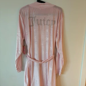 Ljusrosa morgonrock från Juicy Couture - Såå mjuk ljusrosa morgonrock från Juicy Couture med ikoniska loggan på ryggen. Helt ny med tag!
