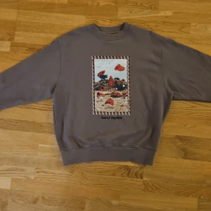 Grå sweatshirt från Daily Paper - Säljer en grå sweatshirt från Daily Paper med ett unikt tryck på framsidan. Tröjan har långa ärmar och en bekväm passform.