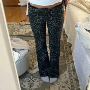 Leopardmönstrade byxor calzedonia - Snygga leopardmönstrade byxor med bootcut-stil. Perfekta för att sticka ut med ett djärvt mönster. Byxorna har en låg midja och är i en mörk färgton. (obs: litet hål längst ner men inget man lägger märke till) 
