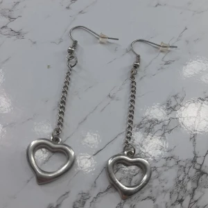 Örhängen  - Det är ett par jätte fina silvriga hjärt örhängen. De har använts ungefär 2 gånger och är i mycket bra skick. Den är köpt för mer än vad priset är lagt på.