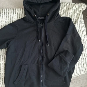 Marinblå vintage hoodie  - Säljer en stilren mörkblå ziphoodie. Den har en dragkedja framtill och en praktisk huva med snörning. Perfekt för en avslappnad look.