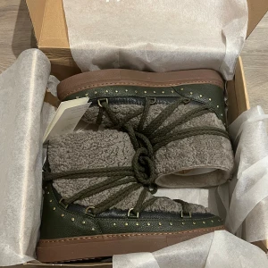 Inuikii vinter skor - Snygga och varma boots i grått och grönt med snörning och dekorativa nitar. De har en mysig insida i fleece och en robust sula som passar perfekt för kyligare dagar. Storlek 40 men passar mig som även har 38/39 i skostorlek🌸