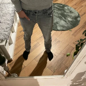 Grå jeans från Jack & Jones - Snygga grå jeans från Jack & Jones med superstretch för extra komfort. De har en klassisk femficksdesign och en normal passform. Perfekta för en avslappnad stil.