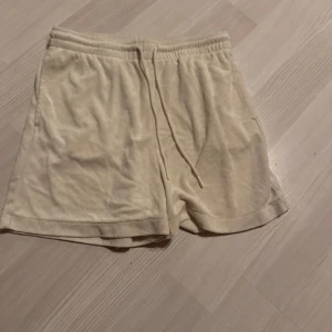 Beige mjukis shorts med snörning - Säljer ett par bekväma beige shorts med elastisk midja och snörning. Perfekta för en avslappnad dag hemma eller ute i solen.