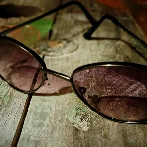Svarta solglasögon med lila tonade glas - Snygga svarta solglasögon med lila tonade glas. Perfekta för en cool look med sina tunna bågar och klassiska design. Passar bra till både vardag och speciella tillfällen.