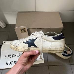 Säljer dessa extremt snygga golden goose superstar navy & white skorna. Köptes på miinto i vintras för 5800kr. Ingår dustbag, box, GG passport och kvitto.  Storlek 40 men sitter större så passar mer som 41. Slitningarna är en del av designen. 