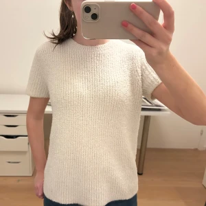 Vit stickad T-shirt  - Säljer en superfin vit stickad topp i mycket bra skick. Den har en enkel och stilren design med korta ärmar och en normal passform. Perfekt nu till hösten.🩷🩷