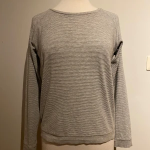 Gråmelerad dam tröja strl 40 från RaceMarine  - Snygg grå randig tröja med långa ärmar. Tröjan har en rund halsringning och är tillverkad i ett mjukt och bekvämt material. 95% Bomull  5% Viscos 