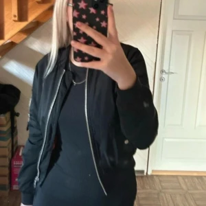 Svart bomberjacka från Bik Bok - Säljer en snygg svart bomberjacka från Bik Bok i storlek XS. Jackan har en dragkedja framtill och är perfekt för höst och vår. Insidan är i en cool orange färg som ger en extra touch. Passar både till vardags och fest!