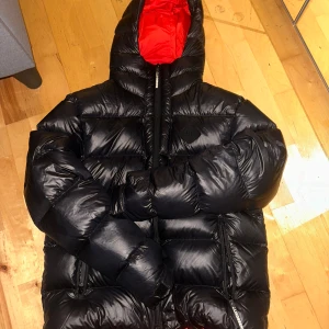 Svart dunjacka från J.Lindeberg - Säljer nu en skit snygg svart dunjacka från J.Lindeberg. Skicket på denna är super bra och den har inga tecken på användning. Nypris på denna ligger på 5200. Hör av er vid minsta lilla intresse!!