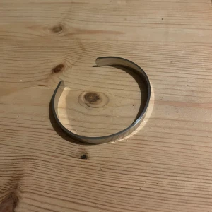  silver armband - Säljer ett stilrent och minimalistiskt armband i silverfärg( Rostfritt Stål ). Det är öppet och justerbart, perfekt för en elegant look. Passar både till vardags och fest. Armbandet är i mycket bra skick och har en modern design som funkar till alla outfits.