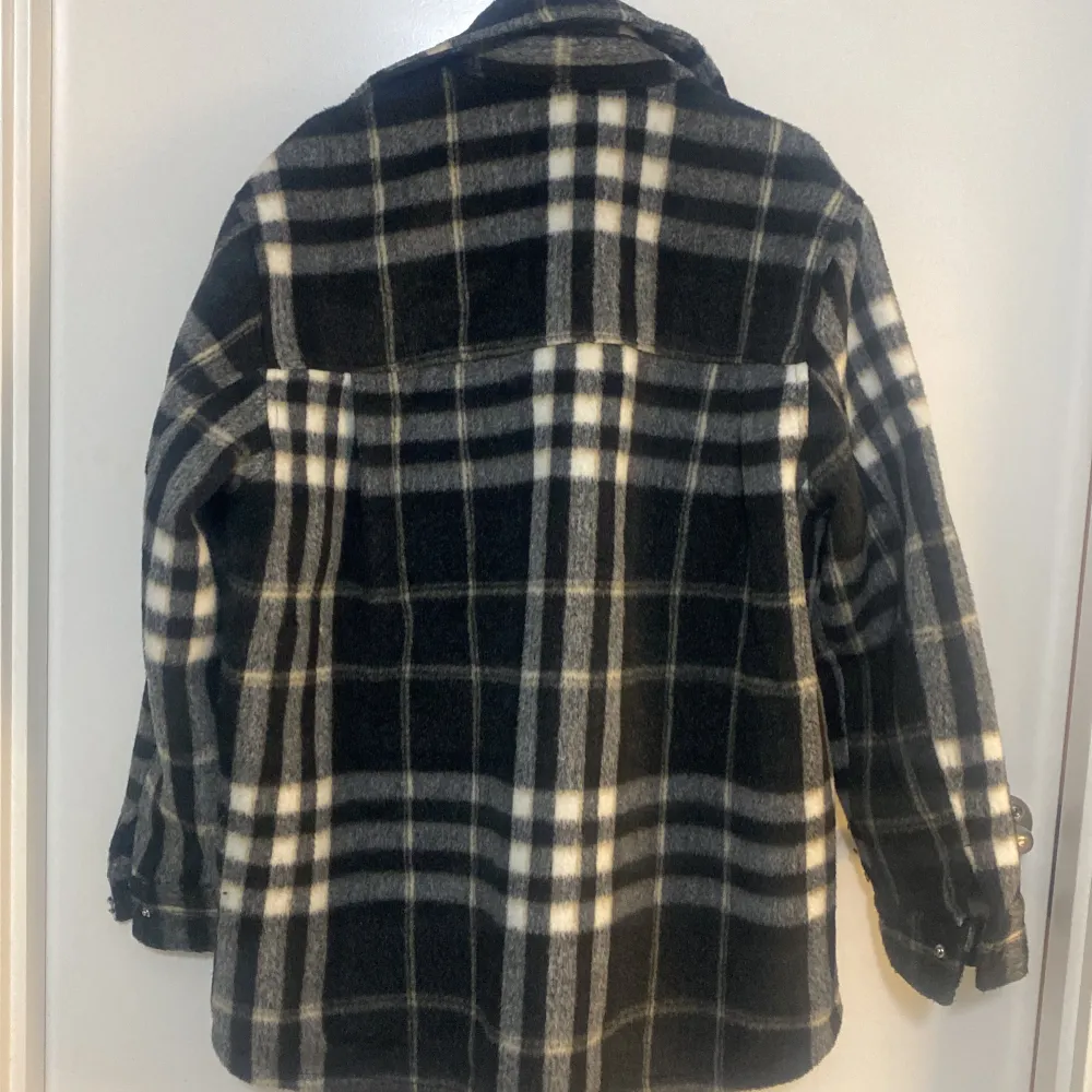 Säljer en snygg rutig overshirt från H&M i svart och vit. Perfekt för höst och vår, med långa ärmar och knappar framtill. Den har två praktiska bröstfickor och är i mycket bra skick. Passar både till vardags och lite mer uppklädda tillfällen. 🖤🤍. Jackor.