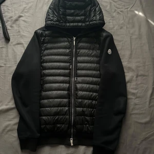 Svart jacka från Moncler - (DEN HAR VARIT UTE ETT TAG NU, BEHÖVER VERKLIGEN FÅ DEN SÅLD INOM EN VECKA SÅ VID SNABB AFFÄR SKULLE MAN KUNNA FIXA ETT JÄTTE VÄRDIGT PRIS!!!) Säljer en snygg svart jacka från Moncler i storlek L men passar som S/M. Den har en quiltad framsida med dragkedja och en huva. Äkta såklart. Det kan du se på bild 4 och 5. Cond 7/10 den är bara lite smutsig! Går bort i kemtvätt, den har redan kemtvättats en gång innan. Priset kan man diskutera men inga skam bud‼️Skriv vid fler frågor eller funderingar🙏🏻