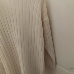 Beige ribbad tröja - Säljer en supermysig cream/vit ribbad tröja i mycket bra skick. Perfekt för höst och vinter med sina långa ärmar och mjuka material. hålla sig varm och snygg under kyliga dagar, har aldrig använt tröjan.