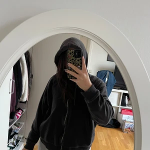Grå hoodie med dragkedja - Säljer en mysig grå hoodie med dragkedja. Perfekt för chill dagar eller när du vill ha något bekvämt och stilrent. Den har en luva och långa ärmar, vilket gör den idealisk för höst och vinter. Passar bra till jeans eller mjukisbyxor.