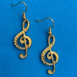 Guldiga örhängen med G-klav design - Snygga guldiga örhängen formade som G-klavar.Nickelfria krokar. Hämtas i Hornstull i Stockholm eller skickas mot fraktkostnad. 🥰