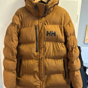 Helly Hansen Adore puffjacka dam - Sparsamt använd mycket varm vinterjacka för kvinnor av hög kvalitet. Huvuddragkedjan fungerar inte men bör kunna repareras, alternativt kan man också stänga framsidan av jackan med knapparna. Annars i mycket bra skick & passform stämmer med storleken