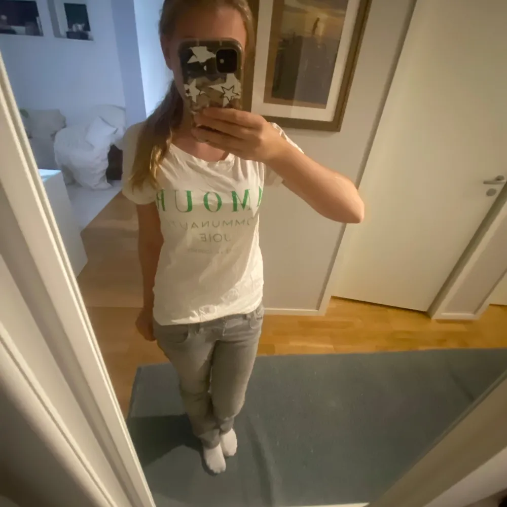 Säljer en vit t-shirt från Lindex i storlek XS. Den har ett grönt tryck med texten 'AMOUR COMMUNAUTÉ JOIE'. Perfekt för en avslappnad stil och passar bra till jeans eller shorts. T-shirten är i bra skick och gjord av bomull.. T-shirts.