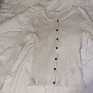 Vit ribbad tröja från H&M - Säljer en superfin vit ribbad tröja från H&M. Den har långa ärmar och knappar hela vägen ner, tröjan är också i bra skick! 🤍