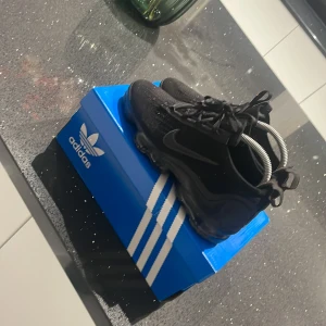 Svarta Nike sneakers - Säljer ett par svarta Nike sneakers i mycket bra skick. De har en cool design med en unik sula och snörning. Perfekta för både träning och vardagsbruk. Skorna är bekväma och stilrena, vilket gör dem till ett måste i garderoben. Pris kan diskuteras!!!!!!