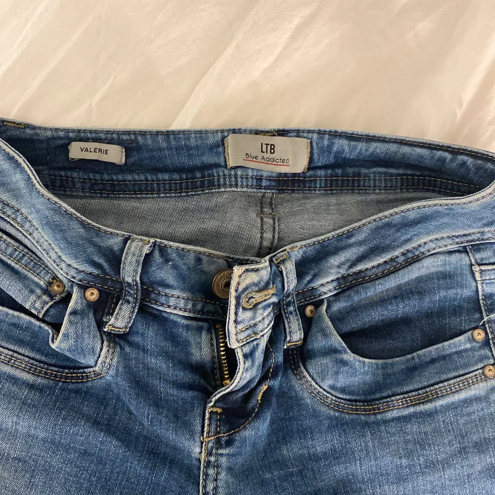 Säljer ett par snygga blå jeans från LTB i modellen Valerie och i storlek 25/30 som är lågmidjade🫶🏻 är perfekta för mig som är 1,60, det är en lite defekt vid gylfen då grejen man drar upp dragkedjan på är borta men man kan fortfarande dra upp kedjan ❤️. Jeans & Byxor.