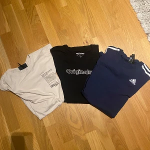 T-Shirt paket från H&M, Jack & Jones och Adidas - Säljer tre snygga t-shirts i storlek S. En beige från H&M med regular fit, en svart från Jack & Jones Originals och en blå från Adidas med klassiska ränder på axlarna. Perfekta för vardagsbruk eller träning!