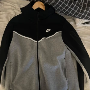 Nike tech - Säljer tre snygga Nike sportjackor i svart/grå, mintgrön och röd. Alla har dragkedja och är långärmade, perfekta för träning eller vardagsbruk. De är i mycket bra skick och har en modern, sportig stil. Passar perfekt för höst och vår!