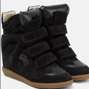 Populära ISABEL MARANT Skor - Säljer ett par svarta skor från Isabel Marant. De har en cool design med kardborreband och en unik textur på ovandelen. Skorna är i skinn och mocka, vilket ger dem en lyxig känsla. De är i använt skick💓 nypris ca 7000