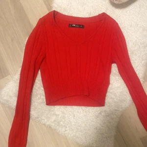Röd ribbad tröja från FB Sister - Säljer en snygg röd ribbad tröja från FB Sister i storlek S. Den är croppad och har en v-ringad design som passar perfekt till vardag. Tröjan är i mycket bra skick och är supermjuk och bekväm att ha på sig. Perfekt för höst och vår!