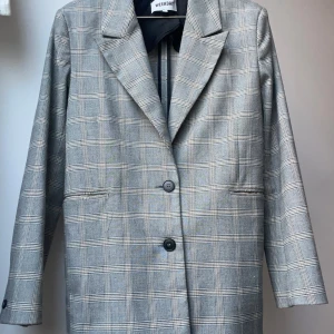 Rutig kavaj - Rutig kavaj, sällan andvänd. Har varsin innerficka på vardera sida. 