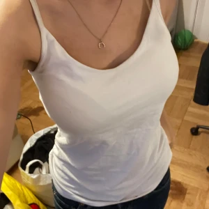 Vit linnetopp - Säljer en enkel och stilren vit linnetopp. Perfekt för sommardagar eller som ett basplagg i garderoben. Toppen har en tight passform och är ärmlös, vilket gör den både bekväm och luftig.