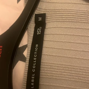  (Endast Swish) Grå ribbad tröja från Lager 157 - Säljer en snygg grå ribbad tröja från lager 157 . Den är i storlek M och har en croppad stil med långa ärmar. Perfekt för både vardag och fest! 🩶