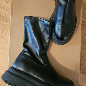 Svarta stövlar - Snygga svarta stövlar med en robust sula. Perfekta för höst och vinter, dessa boots har en stilren design utan snörning eller dragkedja. De är i mycket bra skick, finns få defekter.