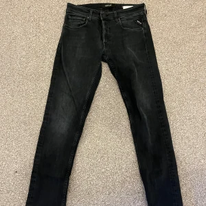 Svarta Replay jeans i bra skick - Säljer ett par svarta jeans från Replay, modellen heter Grover, den är i mycket bra skick. De har en slim passform och är perfekta för både vardag och fest. Jeansen har en klassisk femficksdesign och är tillverkade i ett slitstarkt material. Perfekta för höst och vinter!