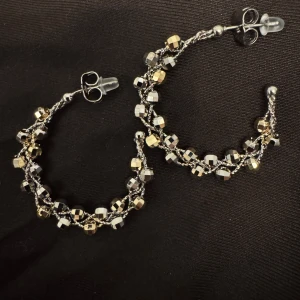 Glittriga örhängen i silver och guld  - Snygga glittriga örhängen i en kombination av silver och guld. De har en unik design med små kubformade detaljer som ger en elegant touch. Perfekta för att lyfta vilken outfit som helst.        14k Guldpläterad 