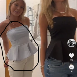 Ljusblå axelbandslös topp - Snygg ljusblå axelbandslös topp med volangdetaljer i midjan. Perfekt för en somrig look eller en utekväll. Toppen har en figurnära passform som framhäver midjan.