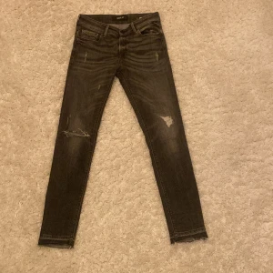 Svarta jeans från Replay - Snygga svarta jeans från Replay i modellen New Luz. De har en tight passform och slitna detaljer för en trendig look. Perfekta för att ge din outfit en cool edge.