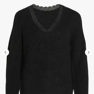 Svart stickad tröja från VILA - Säljer en stilren svart stickad tröja från VILA med v-ringad spetsdetalj vid halsen. Perfekt för kyligare dagar och enkel att matcha med olika outfits.