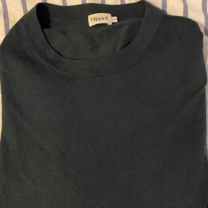 Mörkblå pullover från Filippa K - Säljer en stilren mörkblå pullover från Filippa K. Tröjan har en klassisk design med rund hals och är perfekt för både vardag och mer uppklädda tillfällen. Har använts en del men är fortfarande i fint skick!