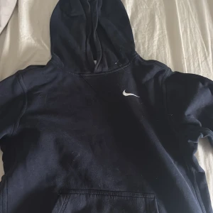 Svart hoodie från Nike - Säljer en mörk blå hoodie från Nike med den ikoniska loggan på bröstet. Hoodien är i storlek XL men för barn (13-15 år) Passae Xs och S. Säljer då jag ej har användning för den längre. Pris kan diskuteras vid snabb affär 🩷