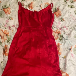 Röd klänning Fashion Nova - Säljer denna superfina klänningen från Fashion Nova som var tänkt att ha till balen. Den är helt oanvänd med prislapp kvar. Klänningen är figursydd och går nedanför fötterna (jag är 164 cm). Den passar perfekt till bal men även bröllop. För fler bilder eller frågor är det bara att skriva! Vid snabb affär kan pris disku
