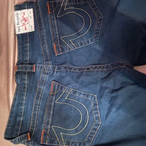 Blå jeans från True Religion - Snygga blå jeans från True Religion med klassisk design och kontrastsömmar. Perfekta för en stilren look. De har en normal passform och är tillverkade i ett slitstarkt material. Byxorna är stretchiga. Även skinny! perfekt om man vill sy om dom till bootcut!😇