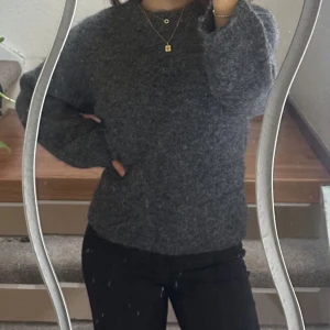 Mörkgrå stickad tröja från Gina Tricot - Säljer en mysig mörkgrå stickad tröja från Gina Tricot. Tröjan har en rund hals och långa ärmar, perfekt för kyliga dagar. Den är i storlek XS och passar utmärkt för en stilren och bekväm look. 