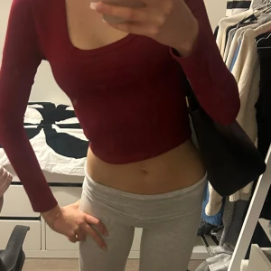 Röd ribbad croppad topp - Snygg röd ribbad topp med lång ärm och croppad passform. Perfekt för en trendig look.