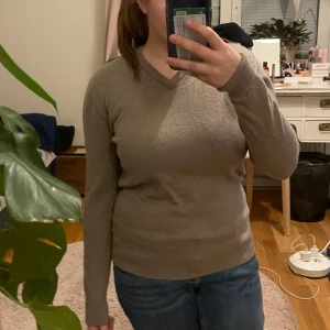 Beige tröja från John Henric - Säljer en stilren beige tröja från John Henric. Tröjan har en v-ringad hals och långa ärmar, perfekt för en avslappnad men ändå elegant look. Passar bra till både jeans och chinos.