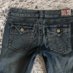 True religion jeans  - Bootcut true religion jeans som är lågmidjade. Har några defekter. De är sönder längst ner då de är lite för långa för mig som är ca 167. Finns även ett litet hål vid bakfickan som inte syns. Har även sytt ihop det🙏